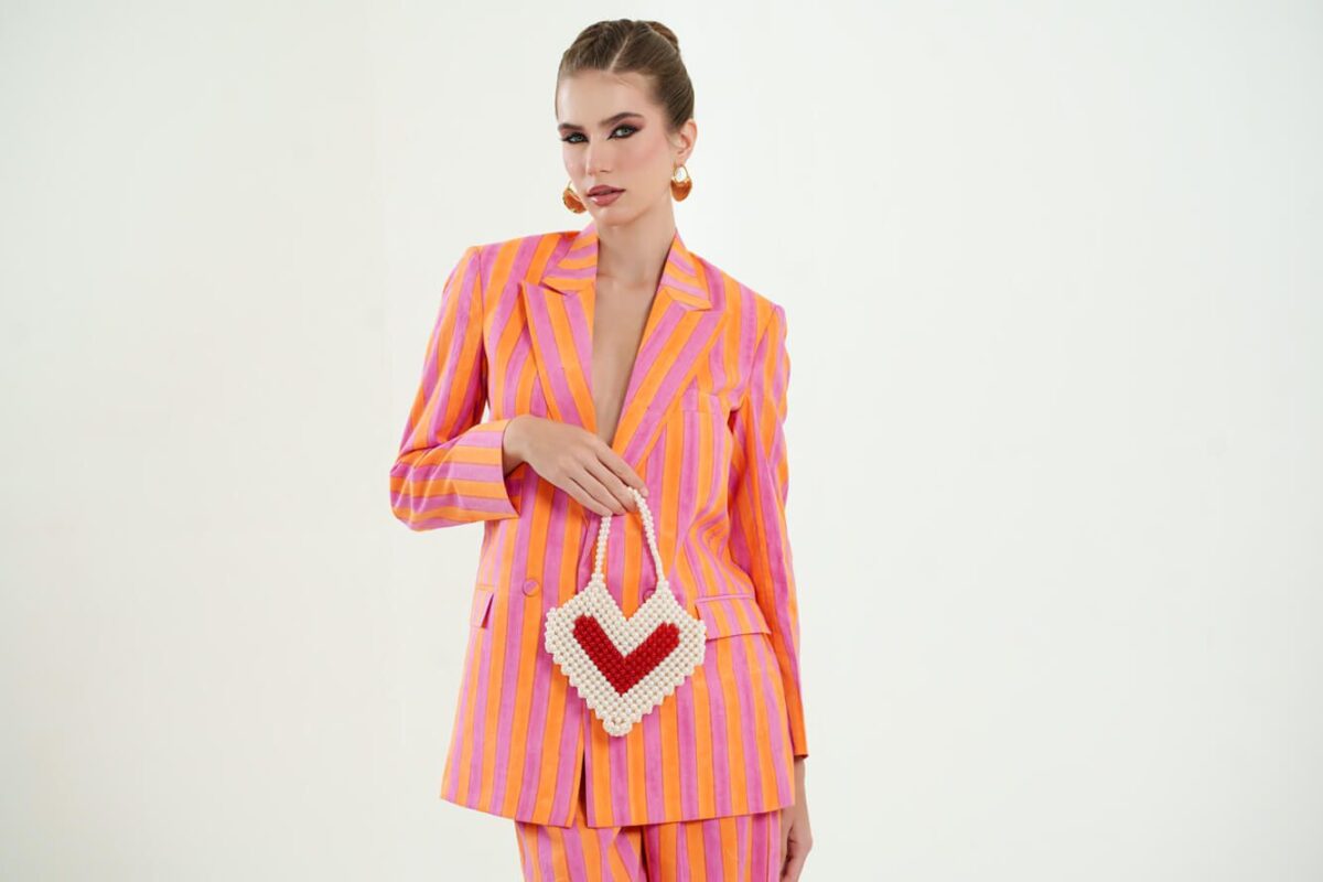 Model wearing the OrPink set and holding a heart shaped purse